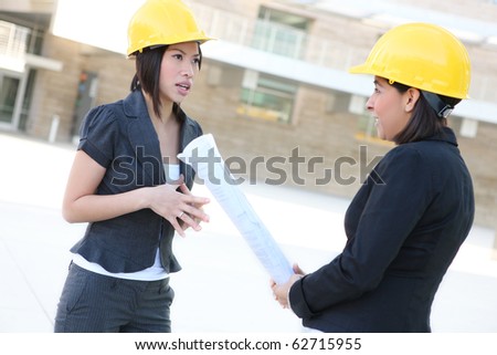 Two pretty diverse women architects on construction building site