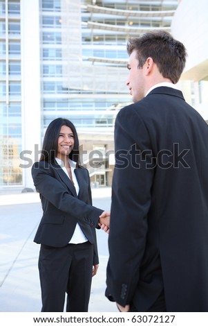 A young attractive diverse man and woman business team handshake at office
