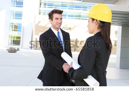 A handsome business man handshake with construction woman at office building