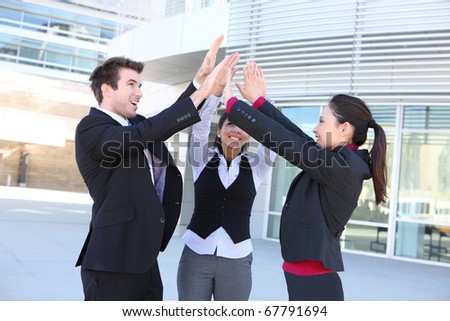 An attractive young business man and woman team celebrating at office building