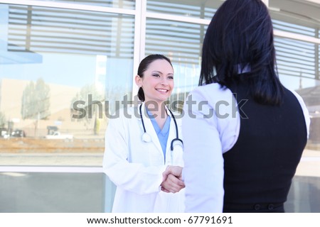 A woman doctor and patient handshake outside hospital