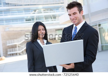 Business people in front of modern building with laptop computer