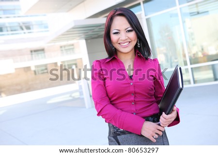 A pretty asian business woman with notebook at office building