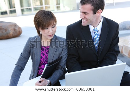 An attractive, diverse business team at the office building with laptop computer