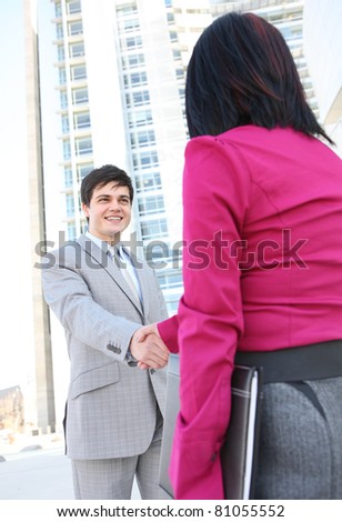 A diverse man and woman  business team shaking hands at office building
