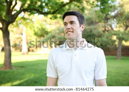 A handsome man in the park happy experiencing nature
