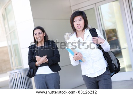Pretty young diverse women on university campus leaving class