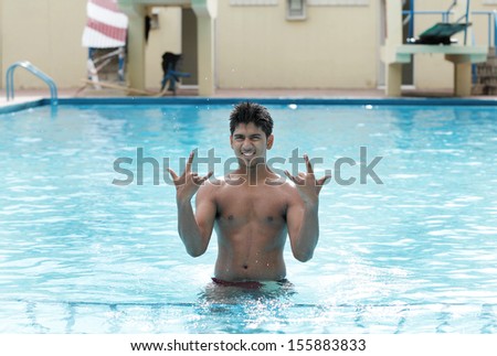 A young swimmer poses in swimming pool