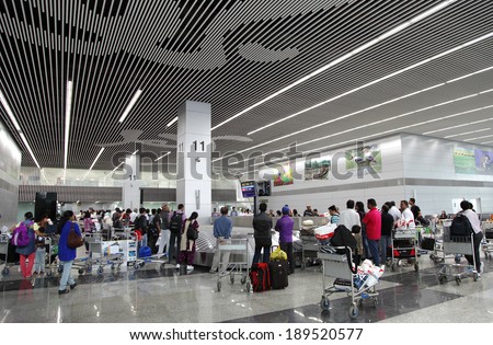 KOLKATA INTERNATIONAL AIRPORT, INDIA- JULY 26: Passengers identifying their baggages on carousel at Kolkata Airport on JULY 26, 2013, Kolkata, India