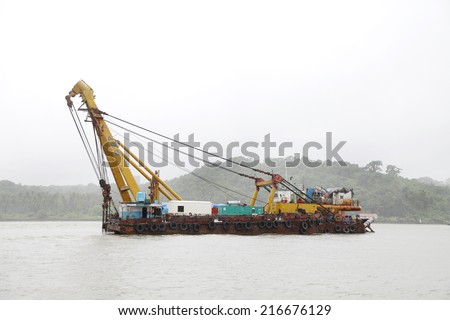 GOA, INDIA- AUGUST 10: Boat equipped with heavy crane to lift cargo and heavy material anchored in the Mandovi river Goa on August 10, 2014, Goa.