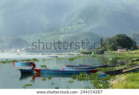 POKHARA, NEPAL-AUGUST 22: A boat woman taking out her boat in the vast Phewa Lake on August 22, 2014, Pokhara, Kathmandu, Nepal.  Phewa lake is a tourist spot located at an altitude of 742 m
