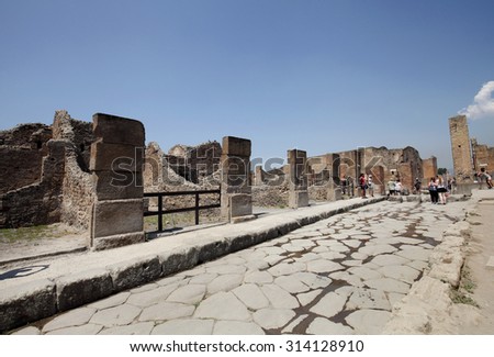 NAPLES, ITALY - JULY 17: Tourists visit the excavated ruins of Pompeii city on July 17, 2015, Naples, Italy. The city was buried under ash and debris during the eruption of Mount Vesuvius in 79 AD