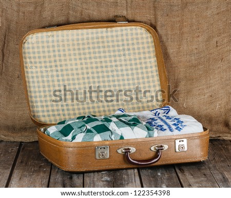 Old shabby suitcase with clothes