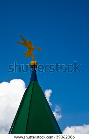 Weather vane in the form of an angel with a pipe on a house spike