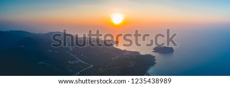 Panorama sunset sky, ocean, island. Aerial drone shot. Thailand. Breathtaking scene the bright sunset over the calm ocean and Ko Pha-ngan island in the Kingdom of Thailand. Perfect spiritual place.
