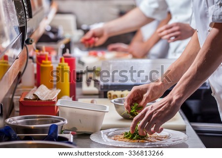 male cooks preparing meals in restaurant kitchen