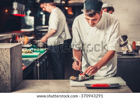male cooks preparing sushi in the restaurant kitchen