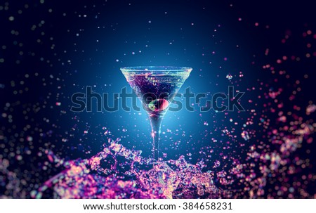 Colourful cocktail in glass with splash on the dark background