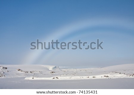 rainbow over snow-covered slopes of the Antarctica