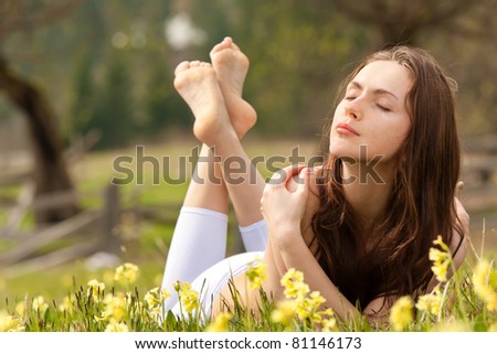 Young woman lying on field dreaming summer day