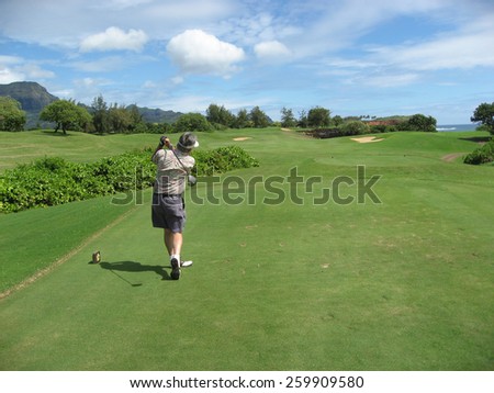 POIPU, USA-February 25, 2008: A senior golfer tees off at a golf course on the island of Kauai.  Golf is a favorite activity of retired people visiting the island.