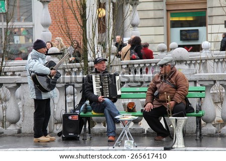 LJUBLJANA, SLOVENIA-MAR. 27, 2015:  Street musicians perform on Preseren Square in Old Town Ljubljana before passing pedestrians.  Musicians are found on every street in old town in good weather.