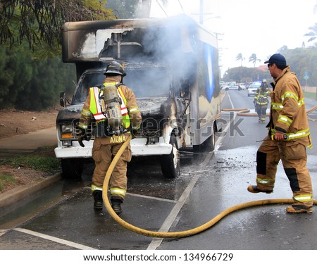 MAUI, HAWAII-APR 12: Firemen responding to a vehicle fire of unknown origin on April 12, 2013 in Maui, Hawaii. The cab and engine compartment were fully engulfed by the fire.