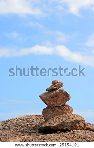 Holy religious Hawaiian spirit stones stacked on clifftop against blue sky