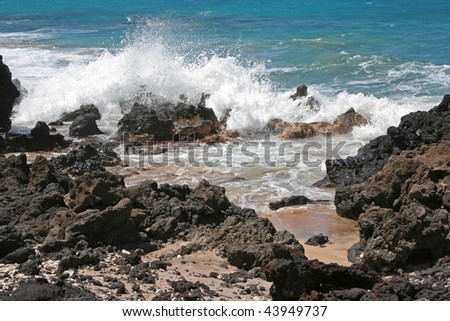 Ocean surf breaks on volcanic rocks in Maui, Hawaii.