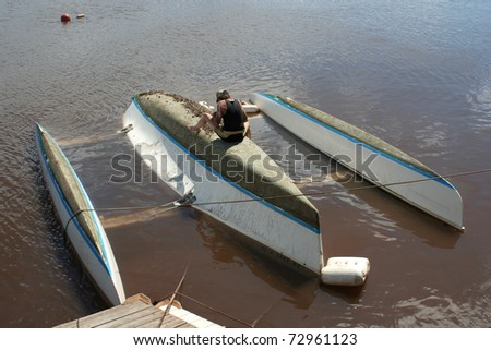 MAUI, HAWAII-MAR 11: Unidentified owner repairs boat capsized and damaged by tsunami from Japanese earthquake on March 11, 2011 in Maui, Hawaii.