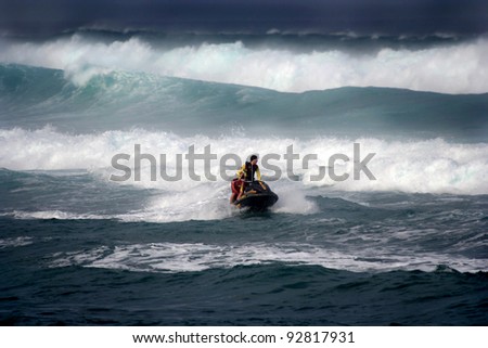MAUI, HAWAII-JAN 5: Lifeguards on a motorcraft fight winter waves in a successful rescue of a surfer in distress January 5, 2012 in Maui, Hawaii.
