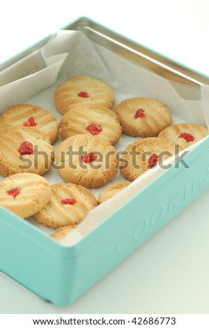 pale blue cookie tin with butter cookies decorated with glace cherries