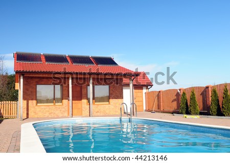 swimming pool in front of small bungalow with solar panels on roof solar panels for swimming pools 450x319 stock photo swimming pool in front of small bungalow with solar panels on roof 44213146 Solar Panels For Swimming Pools