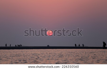 Sunrise on seashore with flying birds at Kuakata, Bangladesh