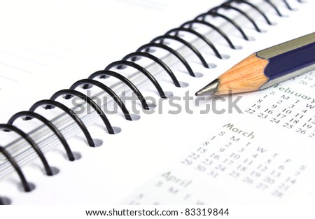 Spiral bound note book with writing pencil