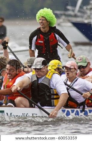 SAINT JOHN, CANADA - AUGUST 28: A sweep in a green wig steers his boat at the Saint John Dragon Boat Festival, a St. Joseph\'s Hospital Foundation fundraiser, on August 28, 2010 in Saint John, Canada.