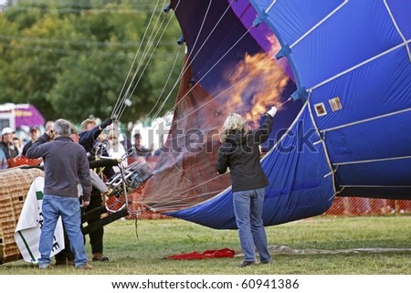 SUSSEX, CANADA - SEPTEMBER 12: The crew steadies the hot air balloon as a big flame enters the envelope at the 2010 Atlantic International Balloon Fiesta on September 12, 2010 in Sussex, Canada.