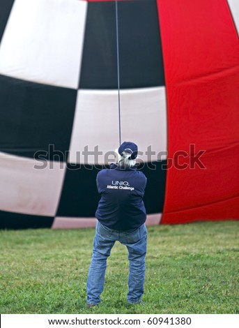 SUSSEX, CANADA - SEPTEMBER 12: A crew member steadies a hot air balloon at the 2010 Atlantic International Balloon Fiesta on September 12, 2010 in Sussex, Canada.