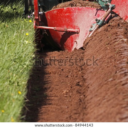 The curved mouldboard of a plough and the resulting furrow.