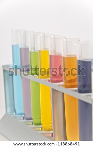 Glass test tubes filled with different coloured liquids.