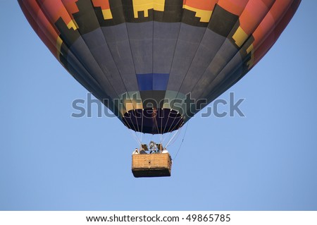 Hot Air Balloon with people in the clear blue sky
