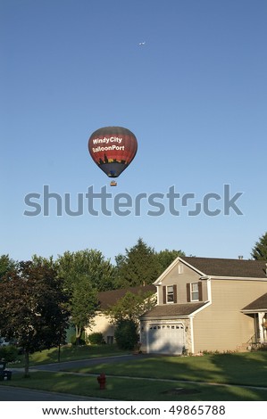 CHICAGO, IL - JULY 5: Hot air balloon with people in the clear blue sky performs sightseeing over the suburbs July 5, 2008 in Chicago, IL