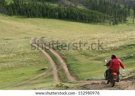 BAT-ULZII, MONGOLIA, JULY, 12 - Two men riding a bike through the mountain tracks, on July 12, 2013 in Bat-Ulzii, Mongolia. Half of mongolian population has a nomadic life.