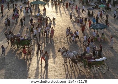 MARRAKESH, MOROCCO - MAY 9 : Tourists at sunset on Djemaa El Fna square, in Marrakesh, Morocco on May 9, 2013. Marrakesh is one of the most touristic place in Morocco.