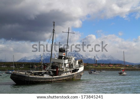 USHUAIA - JANUARY 2, 2014 : Tugboat in the harbor of Ushuaia on the Beagle Channel. The channel was named after the ship HMS Beagle on which traveled Charles Darwin.