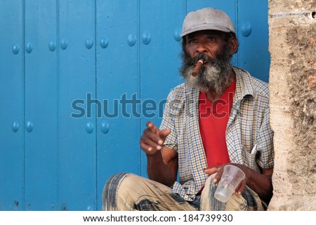 HAVANA, CUBA, FEBRUARY 15, 2014 : Old man smoking cigar in the street. Cigars are a famous Cuban product worldwide and almost the whole production is exported.