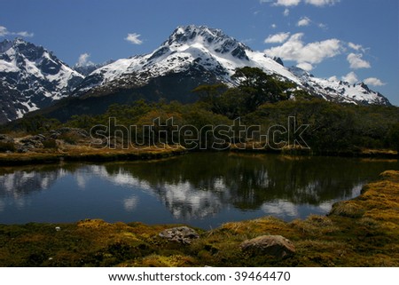 Reflections on Key Summit lake with snow on surrounding mountains