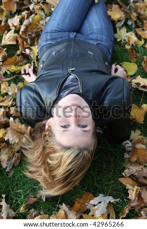girl lying on the yellow leaves head first