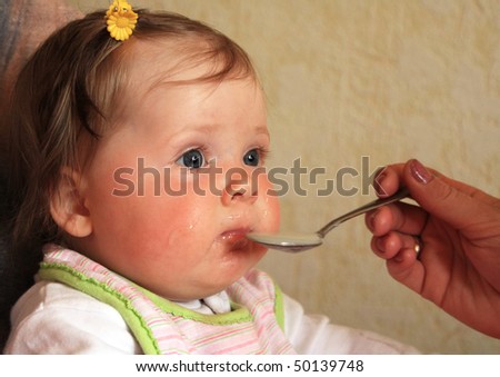 amusing baby with a spoon in a mouth