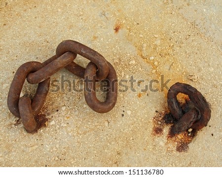 Extreme corrosion of chain link fixed in concrete block. Salt spray corrosion of iron chain in sea port.
